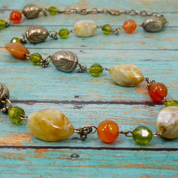 Multi color bead necklace with a mix of beige, green, and deep orange tones. - Picture 6 of 11